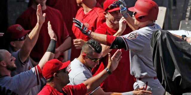 Arizona Diamondbacks' Phil Gosselin is congratulated by teammates as he enters the dugout after hitting a three run home run off the Colorado Rockies during the seventh inning of the first game of a baseball double header Tuesday, Sept. 1, 2015, in Denver. (AP Photo/Jack Dempsey)