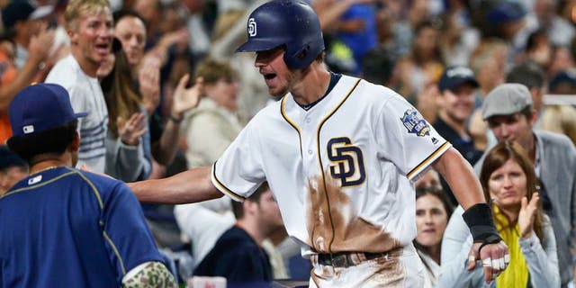 San Diego Padres' Wil Myers is congratulated at the dugout after scoring against the New York Yankees during the sixth inning of a baseball game Saturday, July 2, 2016, in San Diego. (AP Photo/Lenny Ignelzi)