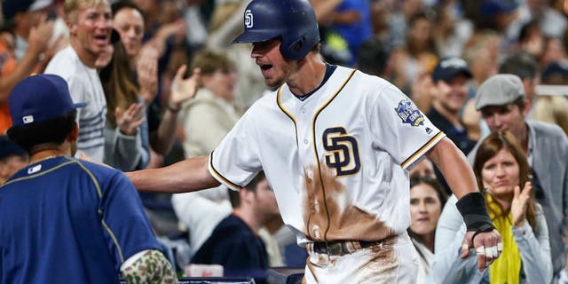 San Diego Padres' Wil Myers is congratulated at the dugout after scoring against the New York Yankees during the sixth inning of a baseball game Saturday, July 2, 2016, in San Diego. (AP Photo/Lenny Ignelzi)