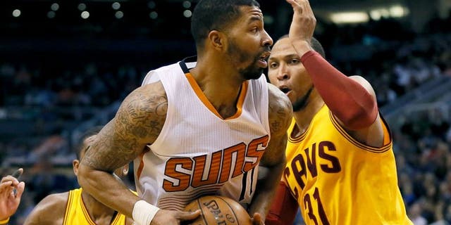 Phoenix Suns' Markieff Morris drives against Cleveland Cavaliers' Shawn Marion during the second half of an NBA basketball game, Tuesday, Jan. 13, 2015, in Phoenix. The Suns won 107-100. (AP Photo/Matt York)