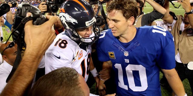 Sep 15, 2013; East Rutherford, NJ, USA; Denver Broncos quarterback Peyton Manning (18) shakes hands with New York Giants quarterback Eli Manning (10) after a game at MetLife Stadium. The Broncos defeated the Giants 41-23. Mandatory Credit: Brad Penner-USA TODAY Sports