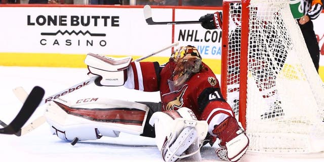Oct 10, 2015; Glendale, AZ, USA; Arizona Coyotes goalie Mike Smith makes a save in the third period against the Pittsburgh Penguins during the home opener at Gila River Arena. The Coyotes defeated the Penguins 2-1. Mandatory Credit: Mark J. Rebilas-USA TODAY Sports