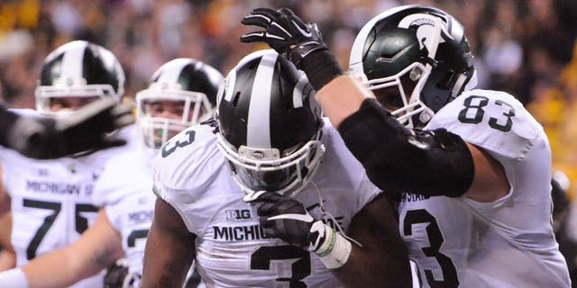 Dec 5, 2015; Indianapolis, IN, USA; Michigan State Spartans running back LJ Scott (3) celebrates the game-winning touchdown with tight end Paul Lang (83) over the Iowa Hawkeyes during the fourth quarter in the Big Ten Conference football championship game at Lucas Oil Stadium. Michigan State won 16-13. Mandatory Credit: Thomas J. Russo-USA TODAY Sports
