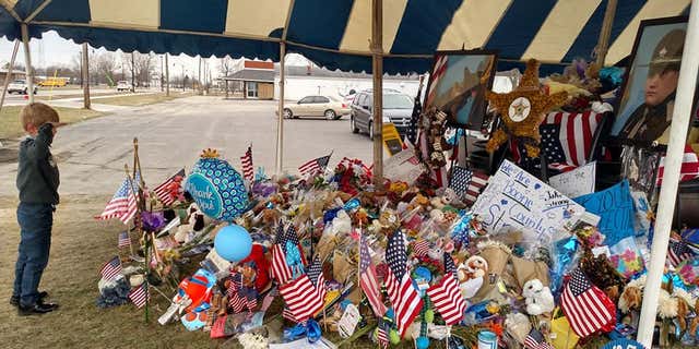 Malachi was pictured saluting the memorial for fallen deputy Jacob Pickett.