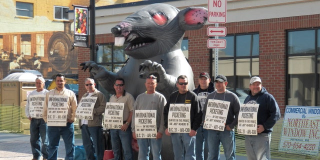 Members of the International Union of Painters and Allied Trades picket in front of the construction site of a new credit union banking location in Pittston, PA that is using non-union labor.