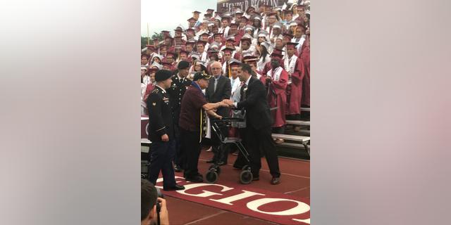 Vito Trause, left, and Principal Dario Sforza, right, shake hands at the Becton Regional High School graduation Wednesday night.