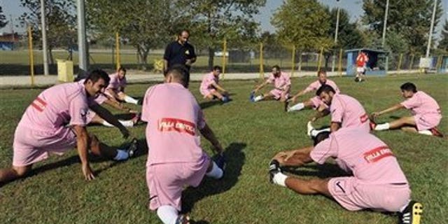 Voukefalas players, a small amateur soccer club, warm up before a local championship match in the city of Larissa, central Greece. A cash-strapped Greek soccer team has found a new way to pay the bills, with help from the world's oldest profession. Players are wearing bright pink practice jerseys emblazoned with the logos of the Villa Erotica and Soulaâs House of History, a pair of pastel-colored bordellos recruited to sponsor the team after drastic government spending cuts left the country's sports organizations facing ruin.
