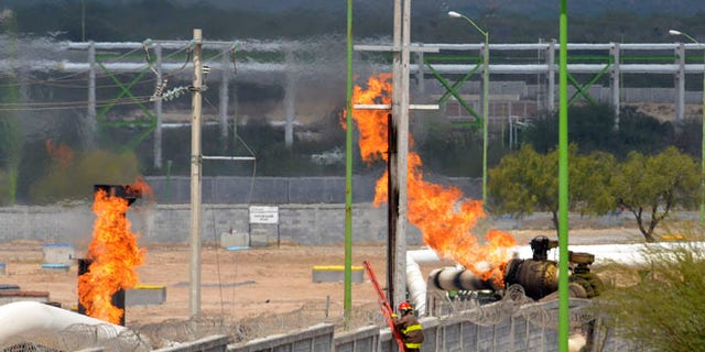 Sept. 18, 2012: Firefighter climb a ladder as they try to control a fire after an explosion at a gas pipeline distribution center in Reynosa, Mexico near Mexico's border with the United States.