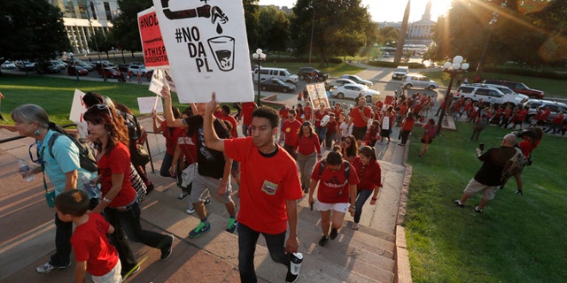 A line of protesters against the construction of the Dakota Access oil pipeline on the Standing Rock Reservation in North Dakota head to a unity rally on the west steps of the State Capitol late Thursday, Sept. 8, 2016, in Denver.