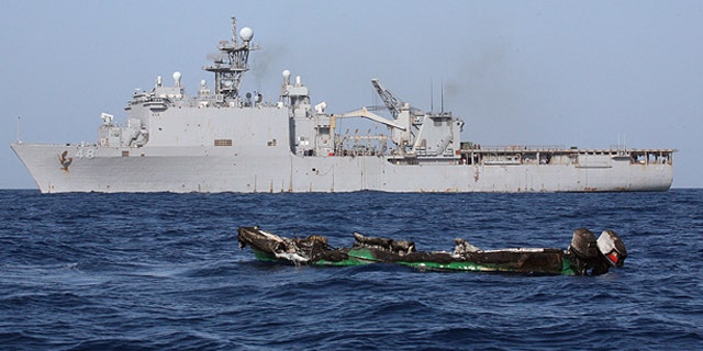 April 10: Suspected pirates skiff drifts at sea after being burnt the amphibious dock landing ship USS Ashland.