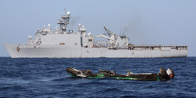 April 10: Suspected pirates skiff drifts at sea after being burnt the amphibious dock landing ship USS Ashland.