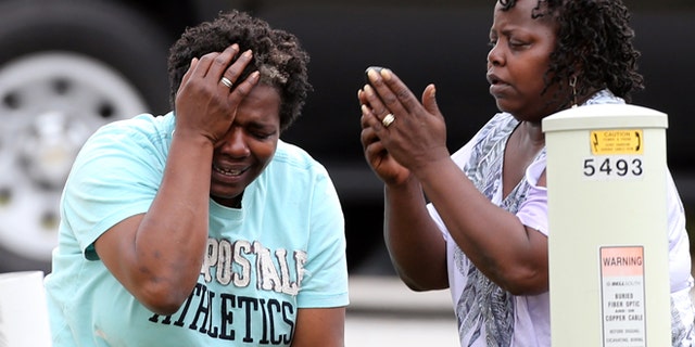 April 24: After finding out that a two-year-old had been killed by his South Fulton family's pit bull, a relative grieves and a family friend makes a call in an unincorporated area in south Fulton County near Union City, Ga.