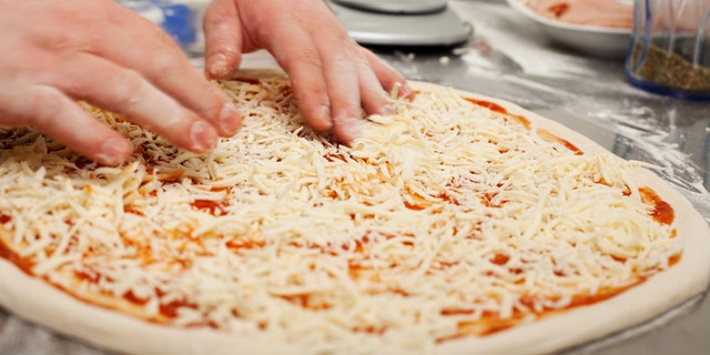 Chef preparing homemade pizza in the kitchen. Motion blur on hands