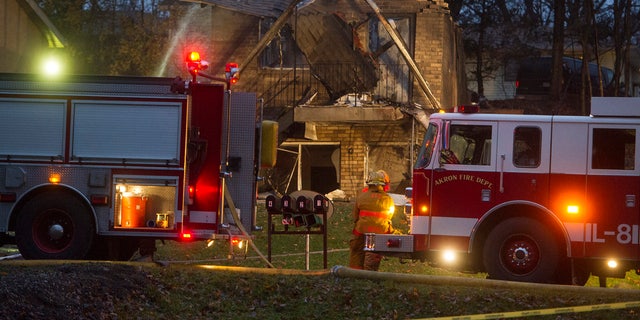 In this Nov. 10, 2015, file photo, firefighters work at the scene where a small business jet crashed into an apartment building in Akron, Ohio.