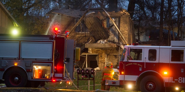 In this Nov. 10, 2015, file photo, firefighters work at the scene where a small business jet crashed into an apartment building in Akron, Ohio.
