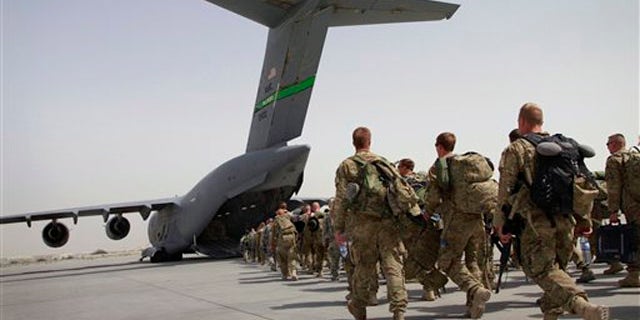 U.S. soldiers walk to board a U.S. military plane, as they leave Afghanistan at the U.S. base in Bagram on July 14.