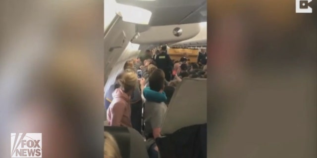 Passengers booed at the five men as they were led off the plane in handcuffs.