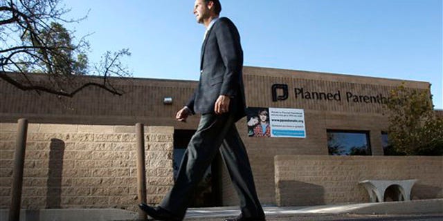 In this Jan. 23 photo, Bryan Howard, CEO of Planned Parenthood Arizona, walks in front of a Planned Parenthood facility in Tucson, Ariz.