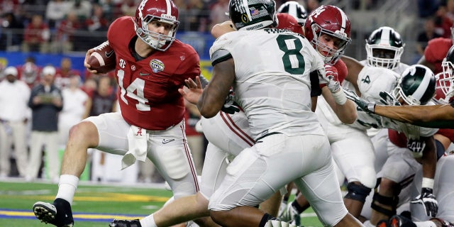 Dec. 31, 2015: Alabama quarterback Jake Coker (14) tries to escape Michigan State's defense during the second half of the Cotton Bowl NCAA college football semifinal playoff game in Arlington, Texas. (AP Photo/Tony Gutierrez)