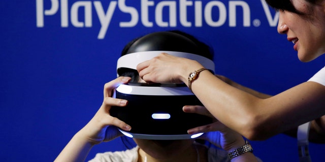 A hostess helps a woman to wear Sony's PlayStation VR headset at Tokyo Game Show 2016 in Chiba, east of Tokyo, Japan, Sept. 15, 2016. (REUTERS/Kim Kyung-Hoon/File Photo)