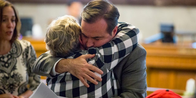 In a Tuesday, April 17, 2018 photo, Cincinatti Mayor John Cranley hugs a member of Kyle Plush's family before the council's Law and Public Safety Committee.
