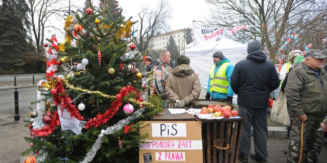 Protesters supporting opposition lawmakers stand next to a Christams Tree in front of the parliament in Warsaw, Poland, Friday, Dec. 23, 2016.