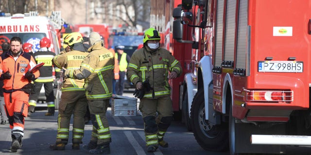 Firefighters and rescuers work at the scene of a building collapse in Poznan, Poland, Sunday, March 4, 2018.