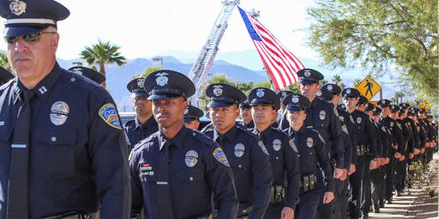 Members of the Palm Springs Police Department walk into the convention center for the services of Palm Springs officers Jose "Gil" Vega and Lesley Zerebny, the two officers who were killed in the line of duty earlier this month, Tuesday, Oct. 18, 2016.  (Jay Calderon/The Desert Sun via AP)