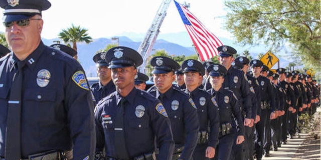 Members of the Palm Springs Police Department walk into the convention center for the services of Palm Springs officers Jose "Gil" Vega and Lesley Zerebny, the two officers who were killed in the line of duty earlier this month, Tuesday, Oct. 18, 2016. (Jay Calderon/The Desert Sun via AP)