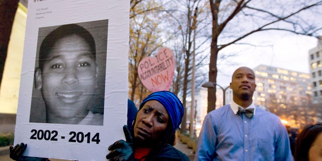 Tomiko Shine holds up a picture of Tamir Rice during a protest in Washington, D.C.