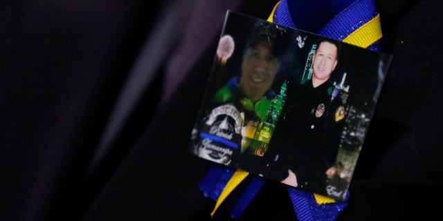 July 16, 2016: A family member wears a ribbon with photos of Patrick Zamarripa during a funeral service for the Dallas police officer