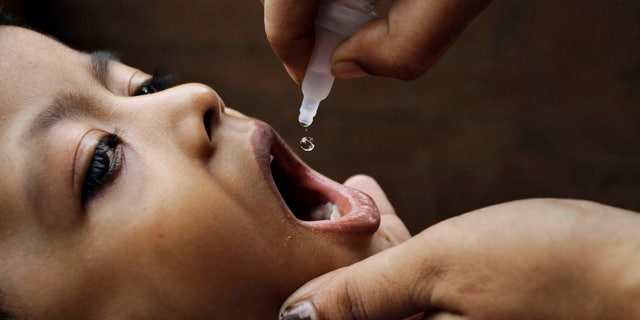 June 17, 2012: In this file photo, a health worker administers a polio drop to an infant in Kolkata, India.