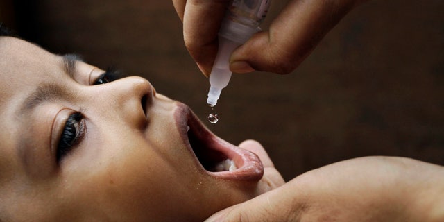 June 17, 2012: In this file photo, a health worker administers a polio drop to an infant in Kolkata, India.