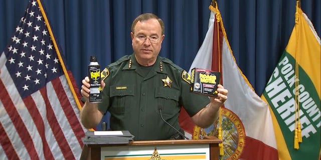 Polk County Sheriff Grady Judd holds roach-killing chemicals as he addresses the media Tuesday.