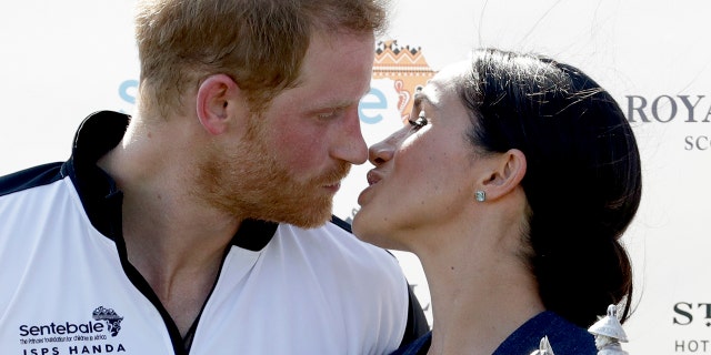 Meghan, Duchess of Sussex and Britain's Prince Harry kiss during the presentation ceremony for the Sentebale ISPS Handa Polo Cup at the Royal County of Berkshire Polo Club in Windsor, England, Thursday, July 26, 2018. (AP Photo/Matt Dunham)