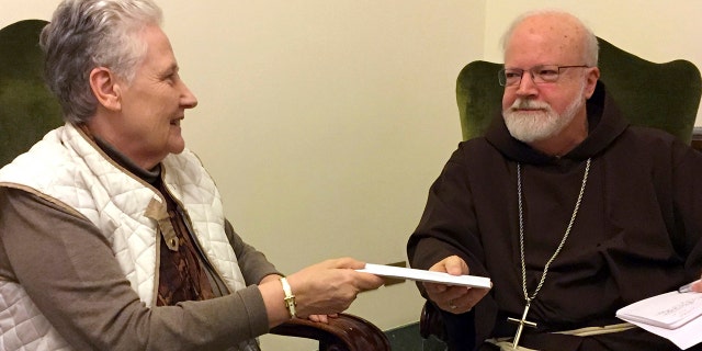 Marie Collins, a member of the pope's sex-abuse commission, hands a letter to Cardinal Sean O'Malley detailing the abuse of Juan Carlos Cruz and a cover-up by Chilean church authorities, at the Domus Santa Marta on April 12, 2015.
