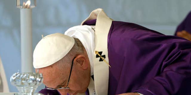 Pope Francis kisses the altar as he celebrates a Mass on the occasion of All Souls' Day, at the Prima Porta Cemetery in Rome, Wednesday, Nov. 2, 2016. (AP Photo/Gregorio Borgia)