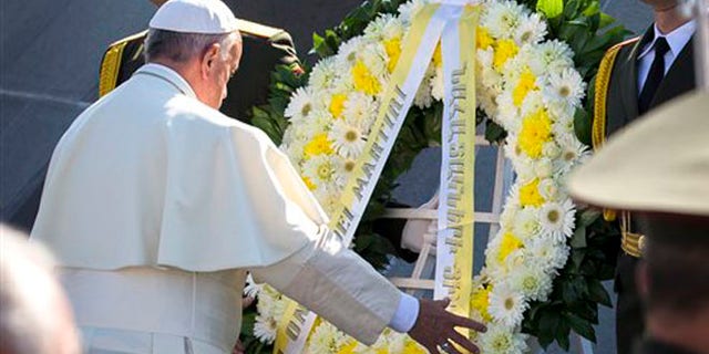 Pope Francis, left, attends a ceremony at a memorial to Armenians killed by the Ottoman Turks in Yerevan, Armenia, Saturday, June 25, 2016. Francis used another opportunity to pay respects to the victims of the slaughter when he visits Armenia's genocide memorial. (AP Photo/Alexander Zemlianichenko)