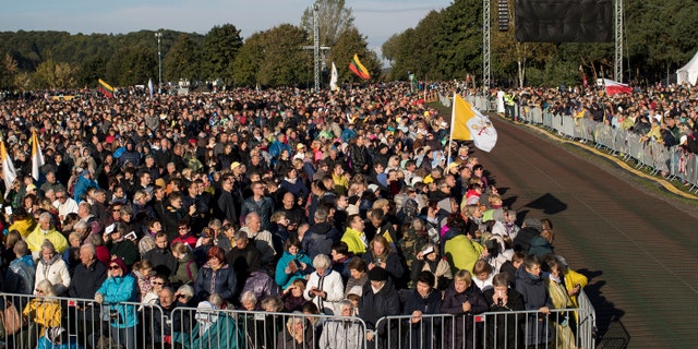 Faithful gather to follow Pope Francis' celebrating Holy Mass at the Confluence Park in Kaunas, Lithuania, Sunday, Sept. 23, 2018.