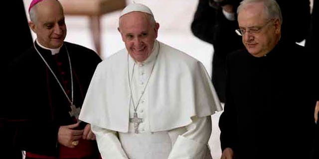 Pope Francis is flanked by Monsignor Vincenzo Paglia and Father Leonardo Sapienza at the end of an audience with workers of the Catholic Shrines in the Paul VI Hall at the Vatican, Thursday, Jan. 21, 2016. (AP Photo/Alessandra Tarantino)