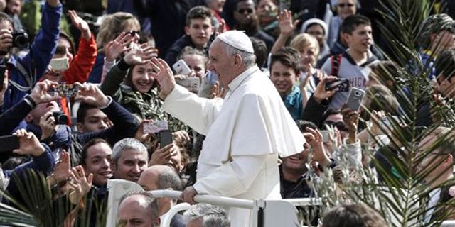 Pope Francis greets faithful after celebrating Palm Sunday Mass, at the Vatican, Sunday, March 20, 2016. Pope Francis in his Palm Sunday homily decried what he called indifference to the refugees flooding into Europe, making a comparison to authorities who washed their hands of Jesus' fate ahead of his crucifixion. 