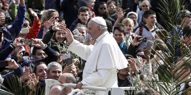 Pope Francis greets faithful after celebrating Palm Sunday Mass, at the Vatican, Sunday, March 20, 2016. Pope Francis in his Palm Sunday homily decried what he called indifference to the refugees flooding into Europe, making a comparison to authorities who washed their hands of Jesus' fate ahead of his crucifixion.