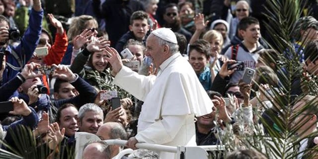 Pope Francis greets faithful after celebrating Palm Sunday Mass, at the Vatican, Sunday, March 20, 2016. Pope Francis in his Palm Sunday homily decried what he called indifference to the refugees flooding into Europe, making a comparison to authorities who washed their hands of Jesus' fate ahead of his crucifixion. 