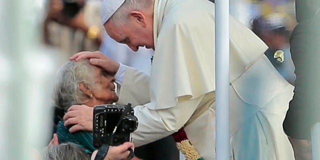 Jan. 14, 2015: Pope Francis reaches out to bless a Sri Lankan Catholic woman during his visit to the Church of Our Lady of Madhu in Madhu, Sri Lanka. (AP)