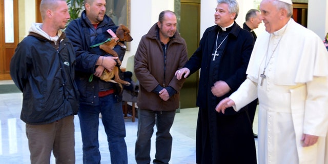Dec. 17, 2013: In this picture provided by the Vatican newspaper L'Osservatore Romano, Pope Francis, right, is flanked by Vatican Almoner Archbishop Konrad Krajewski as he welcomes four men at the Vatican.