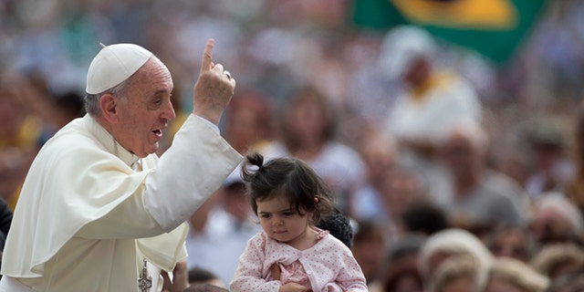 Sept. 11, 2013: Pope Francis arrives for his weekly general audience as a Brazilian flag is being waved in background, in St. Peter square at the Vatican.