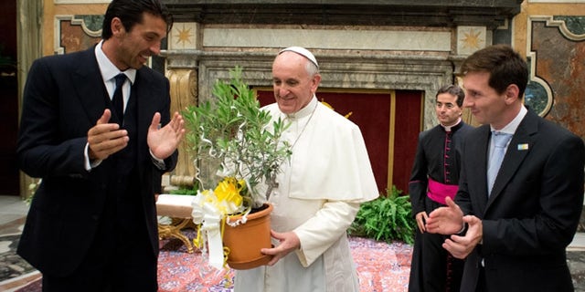 Aug. 13, 2013: In this photo provided by the Vatican newspaper L'Osservatore Romano, Pope Francis is applauded by Italy goalie Gianluigi Buffon, left, and Argentine soccer star Lionel Messi during a private audience at the Vatican.
