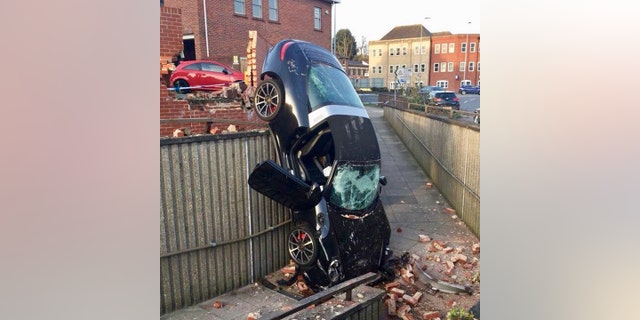 The catastrophic result of a 73 year old's Porsche colliding with a call and crashing into a pedestrian subway. See Masons story MNPORSCHE; The incident happened just after 6pm on Thursday evening (5 Apr). it is believed that the car was parked in a car park before it crashed through the wall. Several police cars and two fire engines were sent to the scene.
