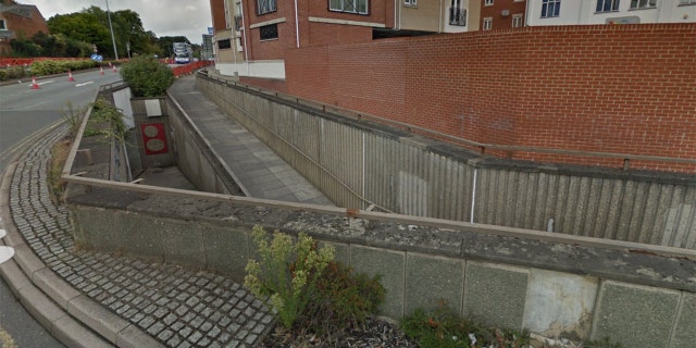 A view of the wall before the accident shows the walkway passing below it.