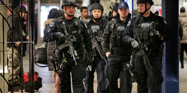 Police officers patrol in the passageway connecting New York City's Port Authority bus terminal and the Times Square subway station.
